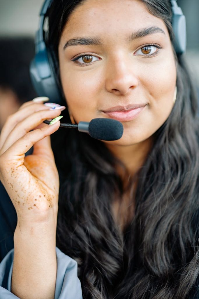 A young woman providing customer support with a headset, smiling confidently.